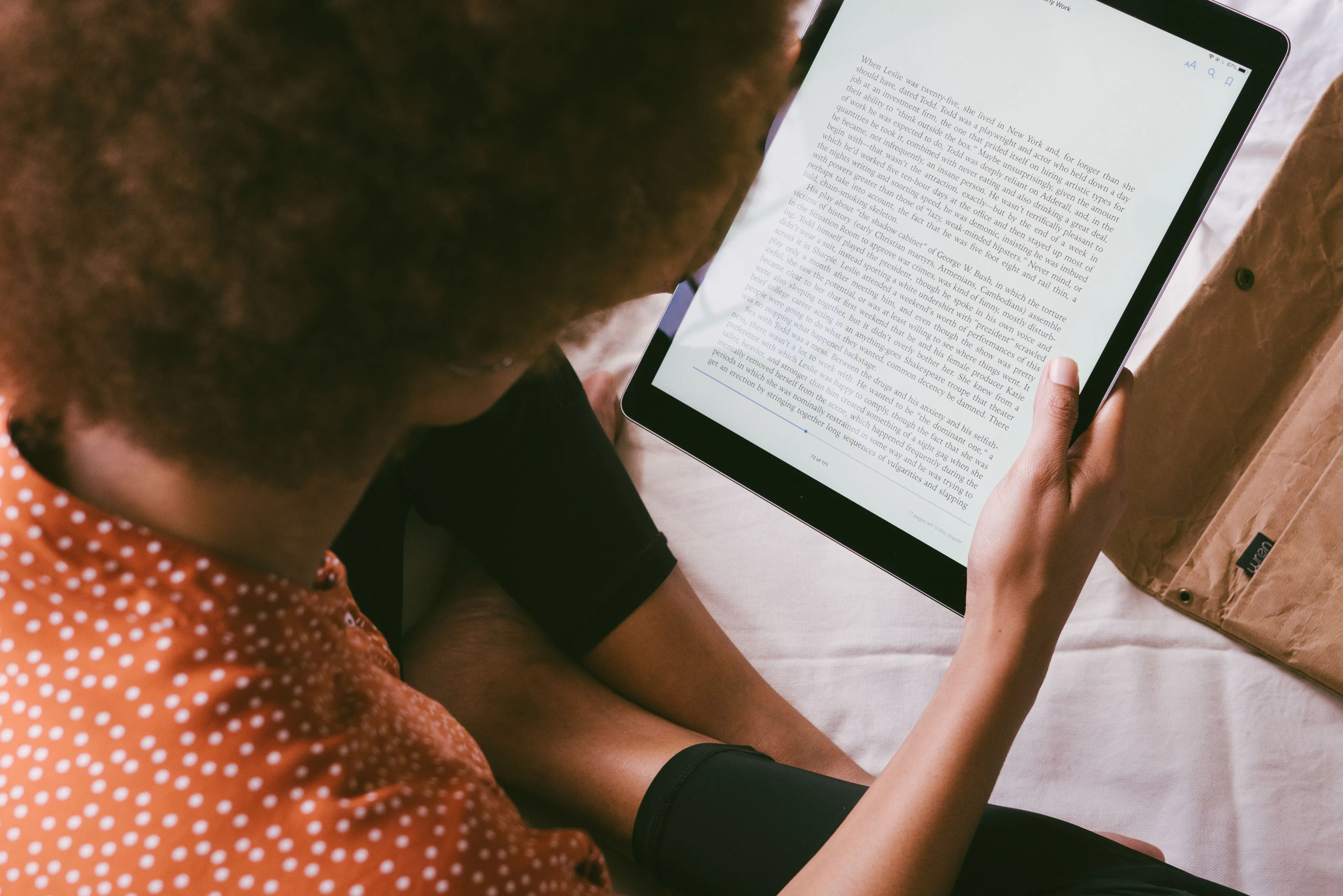 A black woman reading on an ereader.